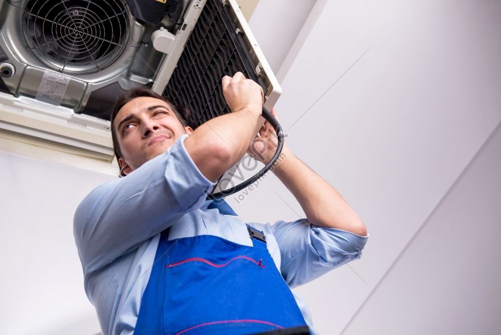 Young Repairman Working On Air Conditioning Unit On Ceiling Photo ...